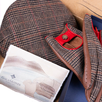 Brown leather driving gloves with red accents, paired with a houndstooth cap and an illustrated care card from Gala Gloves.